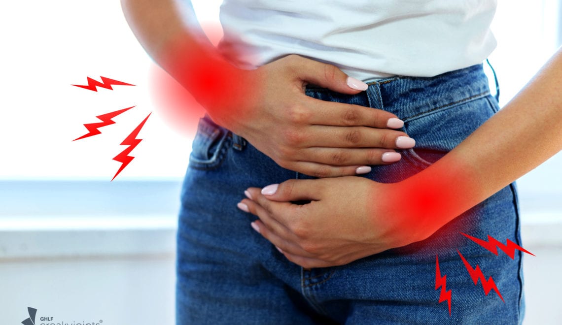 Image shows a woman in jeans and a t shirt holding her pelvis in pain. There are red spots representing arthritis on her wrists