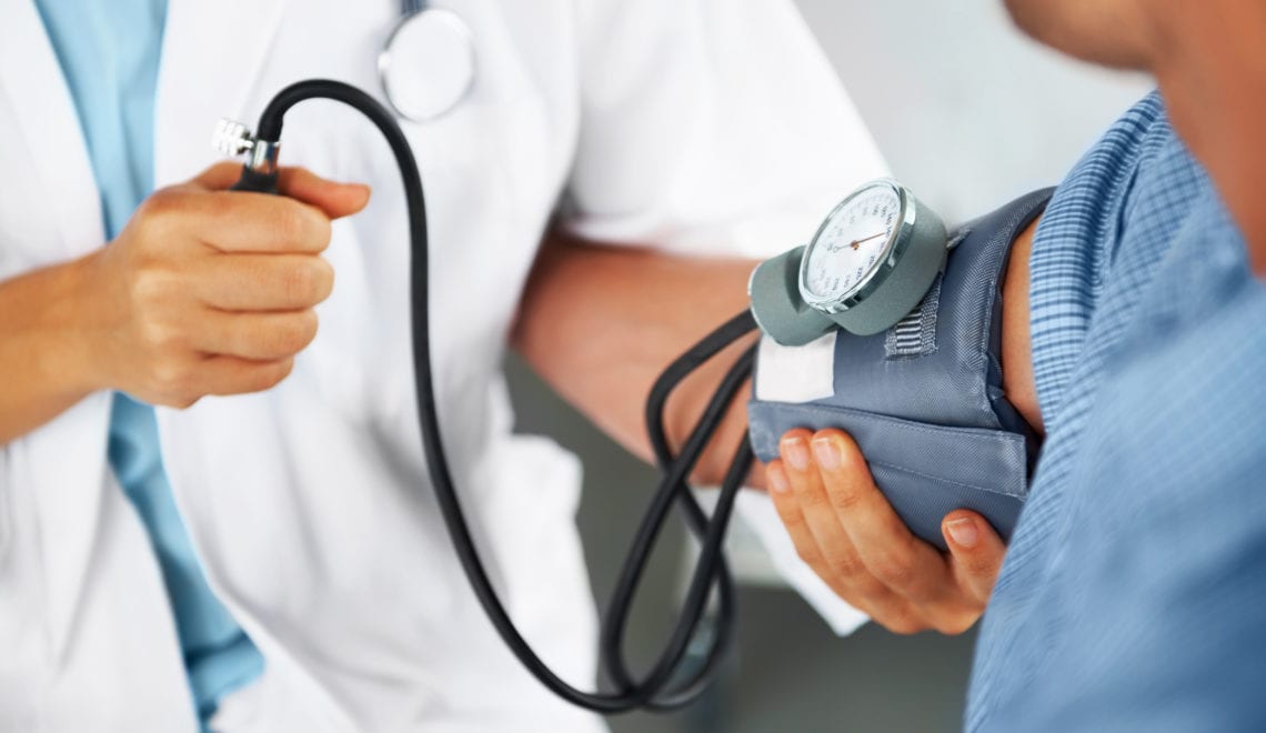 A doctor listening to his patient's heartbeat with a stethoscope.