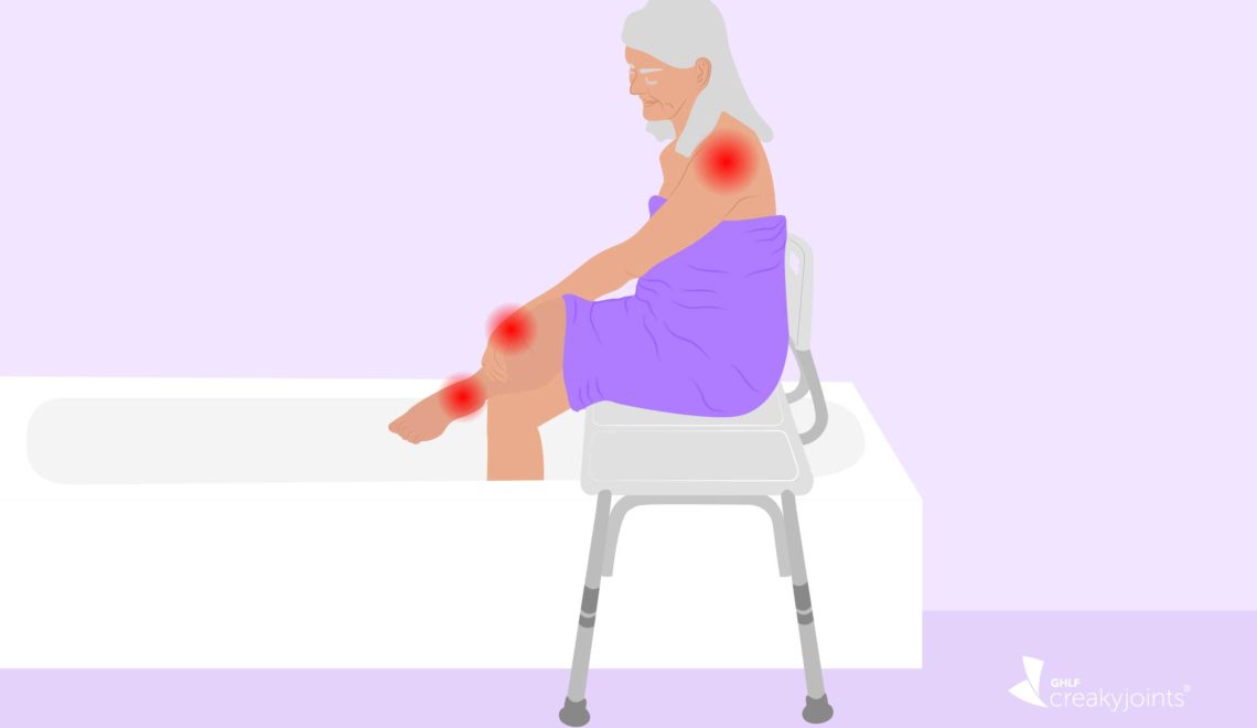 An illustration of a person with arthritis, as evident by red spots on their arms and legs, wrapped in a towel. The person is sitting on a transfer bench, which is located in their shower.