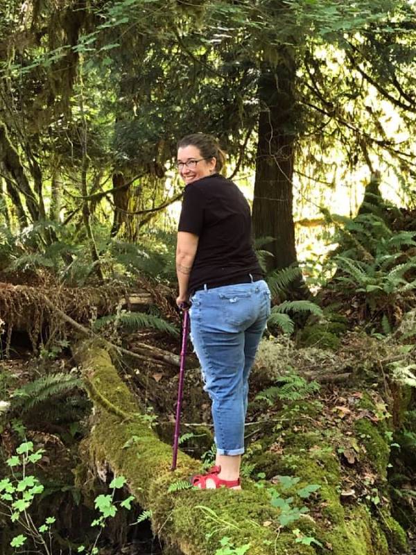 A photo of Angie Ebba, a woman with ankylosing spondyloarthritis, going for a hike with a cane.