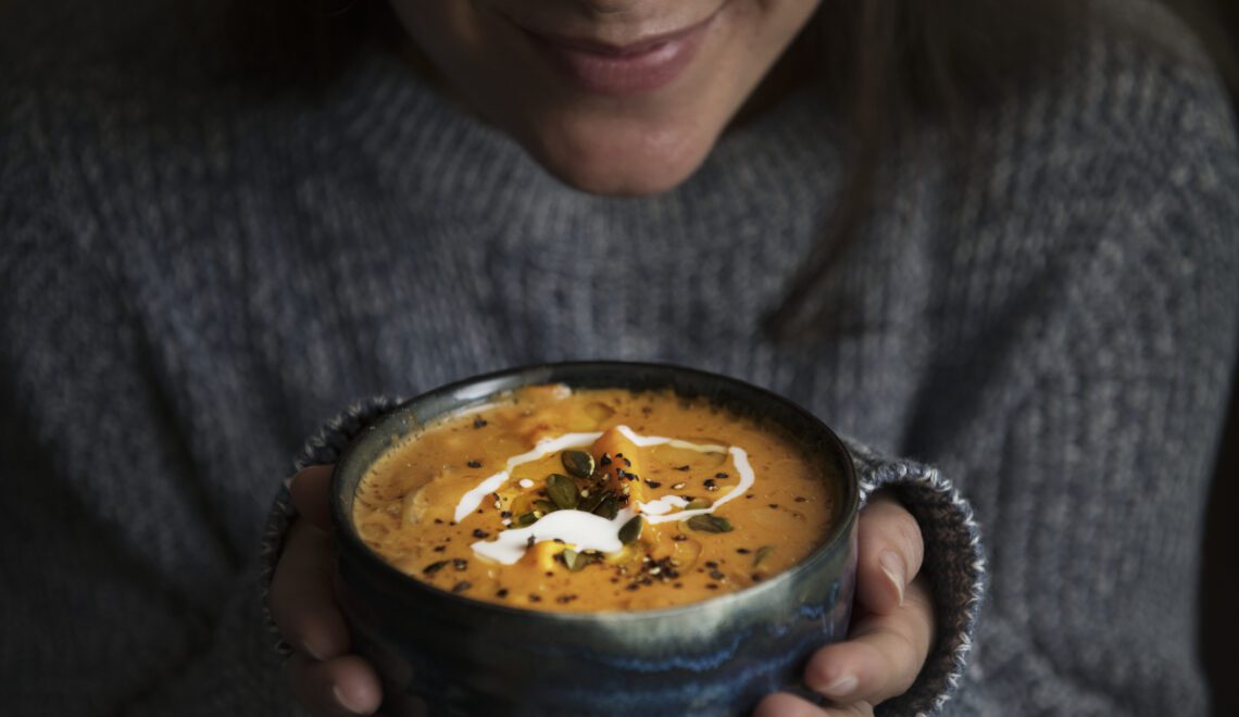 Woman holding a bowl of soup food photography recipe idea