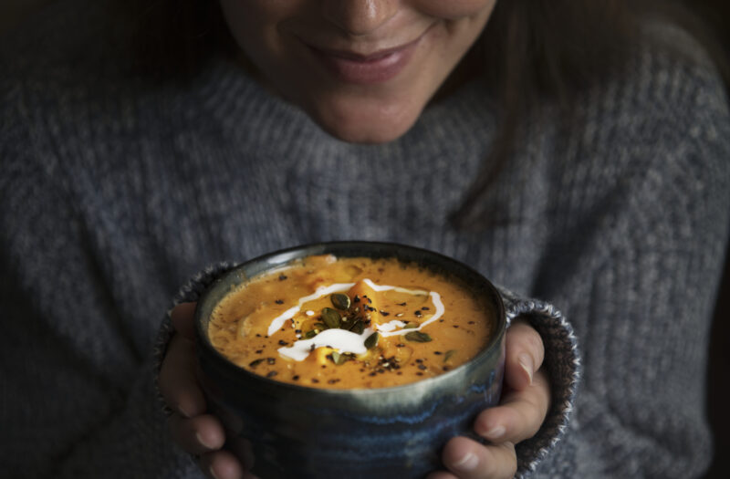 Woman holding a bowl of soup food photography recipe idea